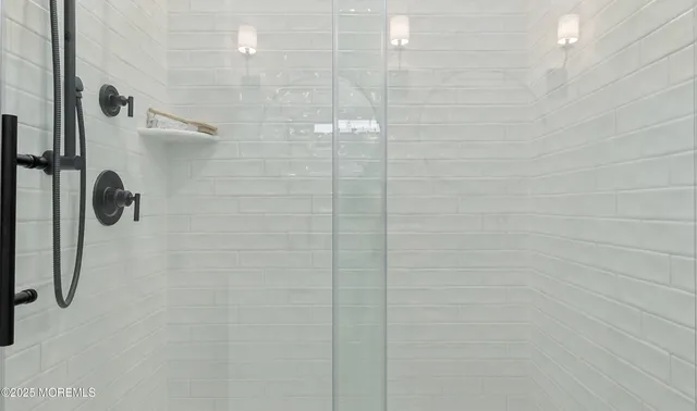 a bathroom with a granite countertop double vanity sink and a mirror