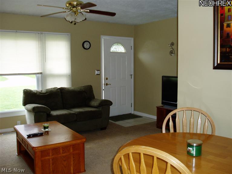 It also features a ceiling fan and opens to the main hall and kitchen.