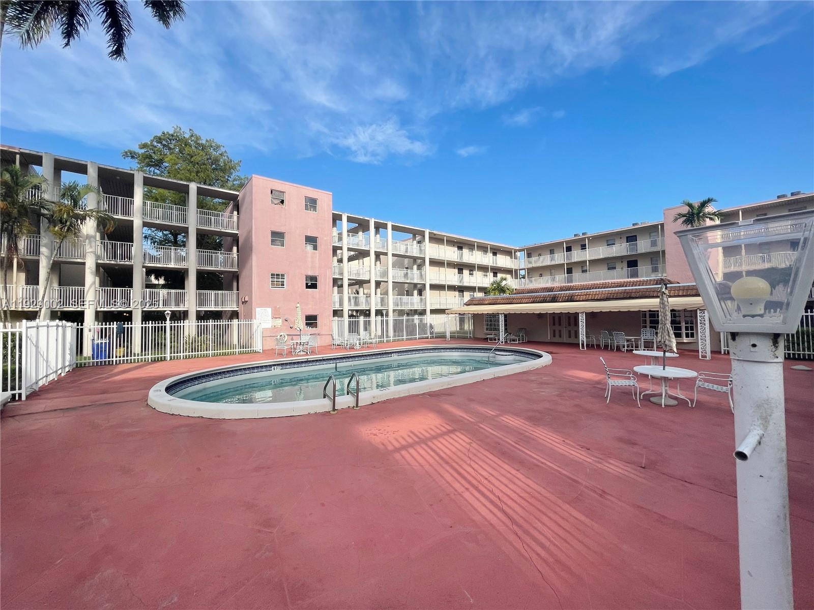 2800 Northwest 56th Avenue, Unit E103 Lauderhill, FL 33313 - Photo 11 of 15 a view of a swimming pool with a yard in front of it