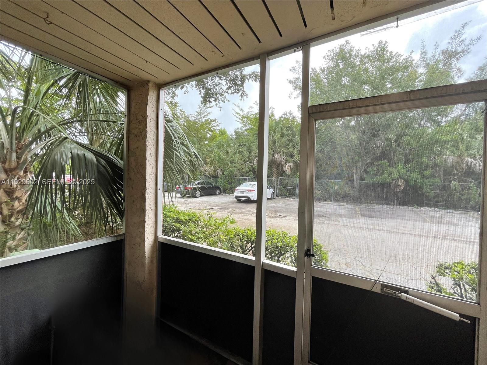2800 Northwest 56th Avenue, Unit E103 Lauderhill, FL 33313 - Photo 3 of 15 a view of a glass door with a trees from a window