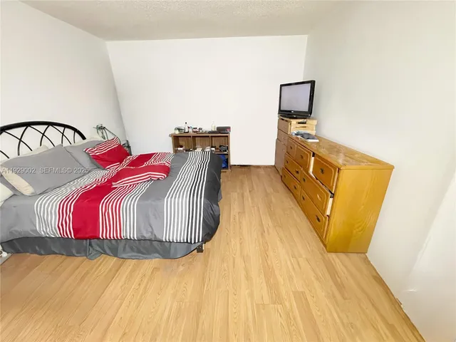 a view of a bedroom with wooden floor