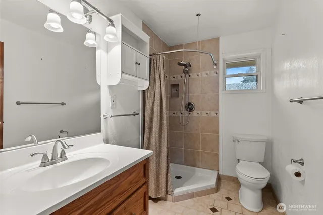a bathroom with a sink toilet a mirror and shower