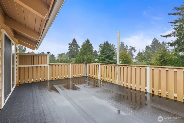 a view of a balcony with wooden floor and fence