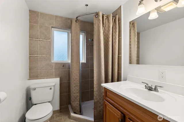 a bathroom with a granite countertop sink toilet and shower