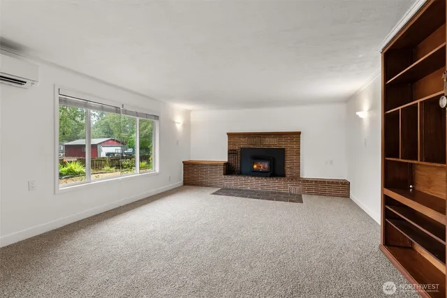 an empty room with windows and fireplace
