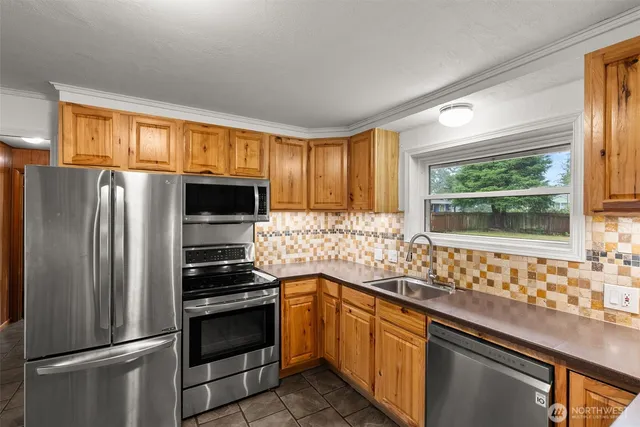 a kitchen with granite countertop a refrigerator and a sink