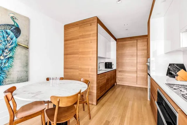 a kitchen with stainless steel appliances a table and chairs in it