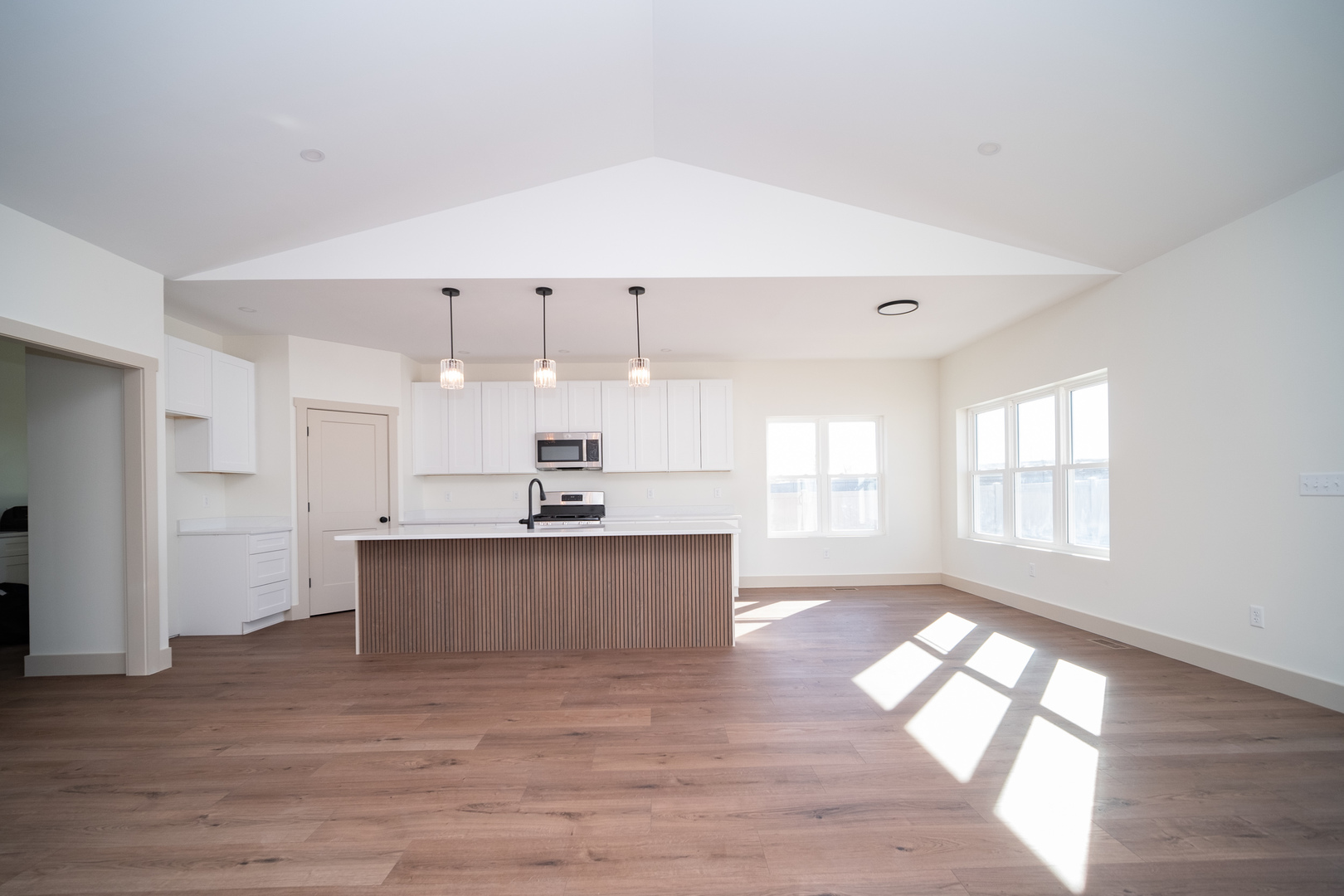 550 Cross Plains Road Rockford, IL 61107 - Photo 7 of 34 a large white kitchen with wooden floors and stainless steel appliances