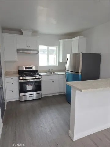 a kitchen with stainless steel appliances a stove a sink and a refrigerator