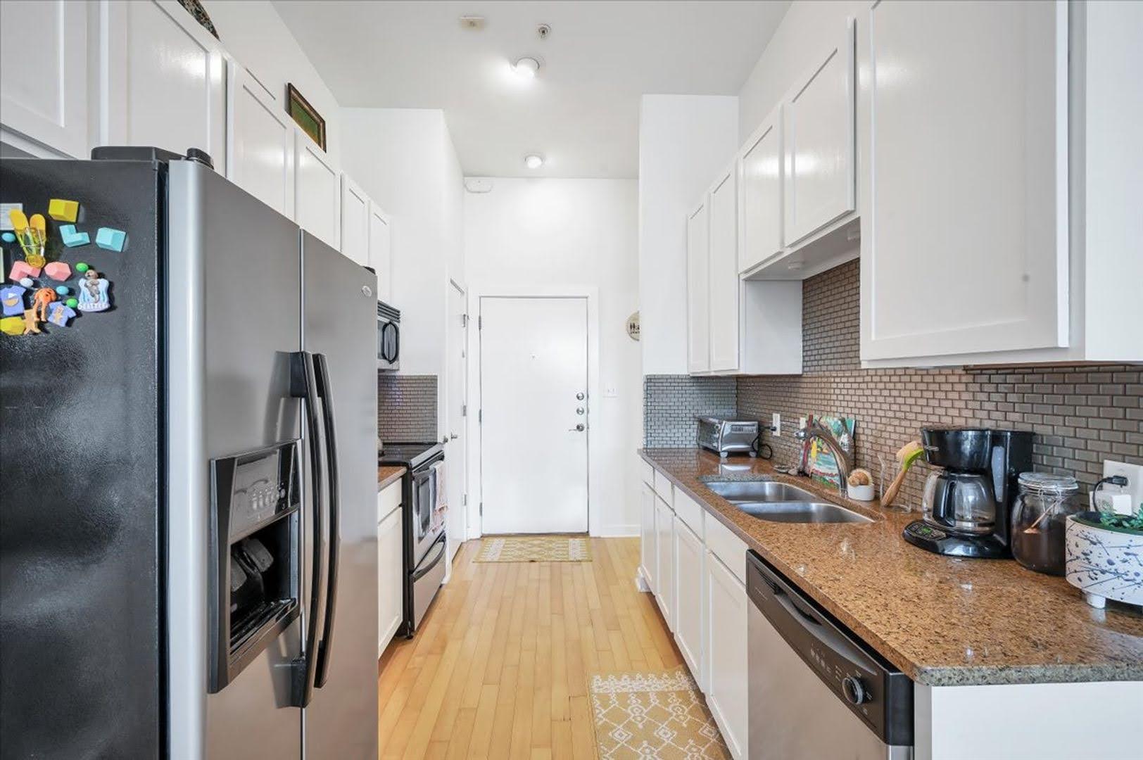 2931 East 12th Street, Unit 306 Austin, TX 78702 - Photo 4 of 19 a kitchen with stainless steel appliances granite countertop a refrigerator a stove and a sink