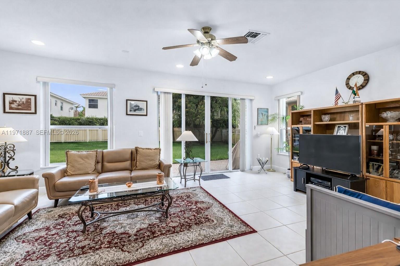 5321 Southwest 184th Way Miramar, FL 33029 - Photo 16 of 43 a living room with furniture a flat screen tv and a floor to ceiling window