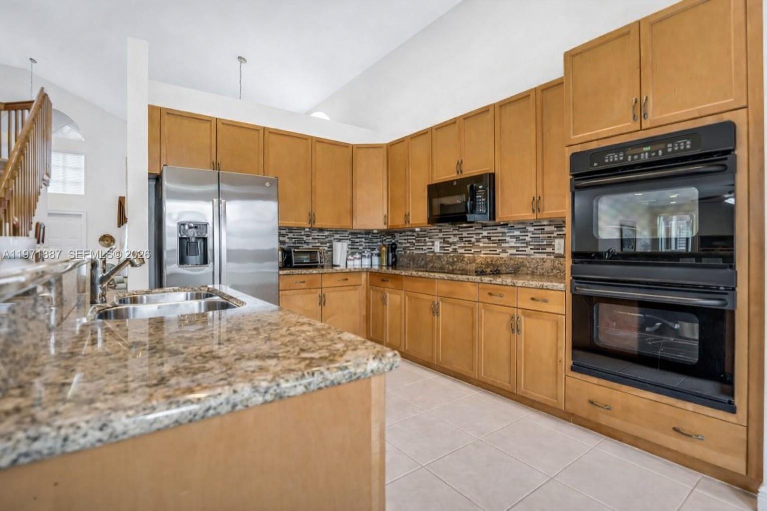 5321 Southwest 184th Way Miramar, FL 33029 - Photo 2 of 43 a kitchen with kitchen island granite countertop a sink stove and microwave
