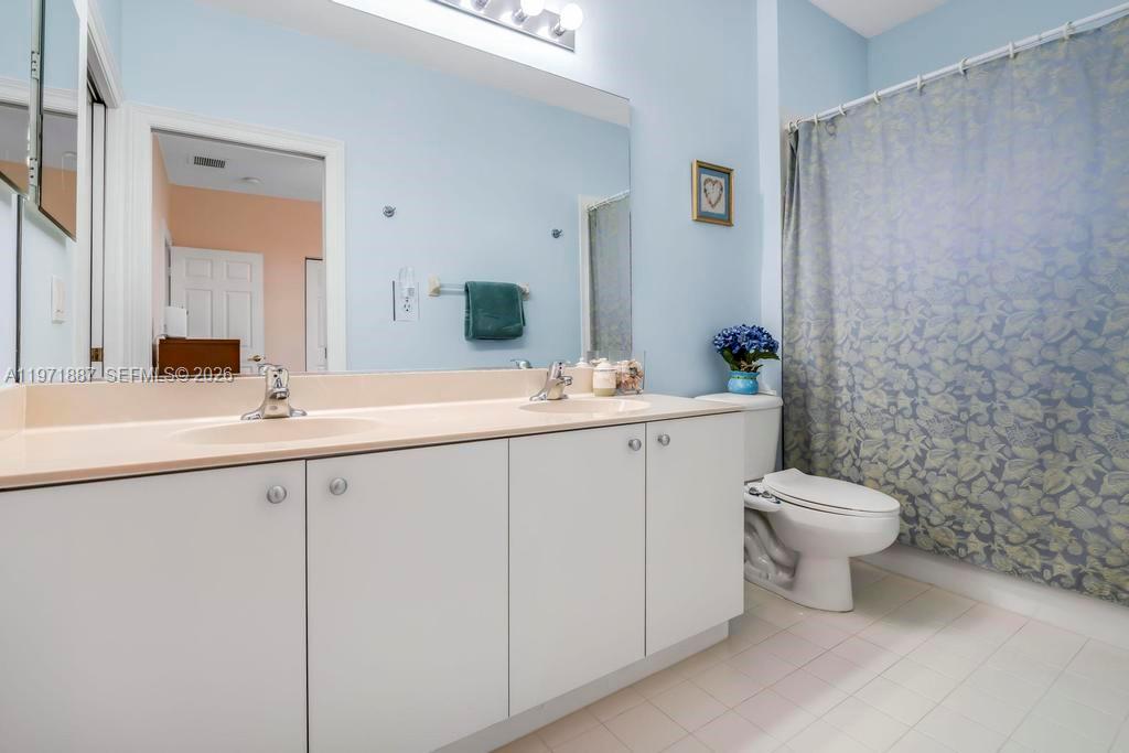 5321 Southwest 184th Way Miramar, FL 33029 - Photo 27 of 43 a bathroom with a double vanity sink toilet and a mirror
