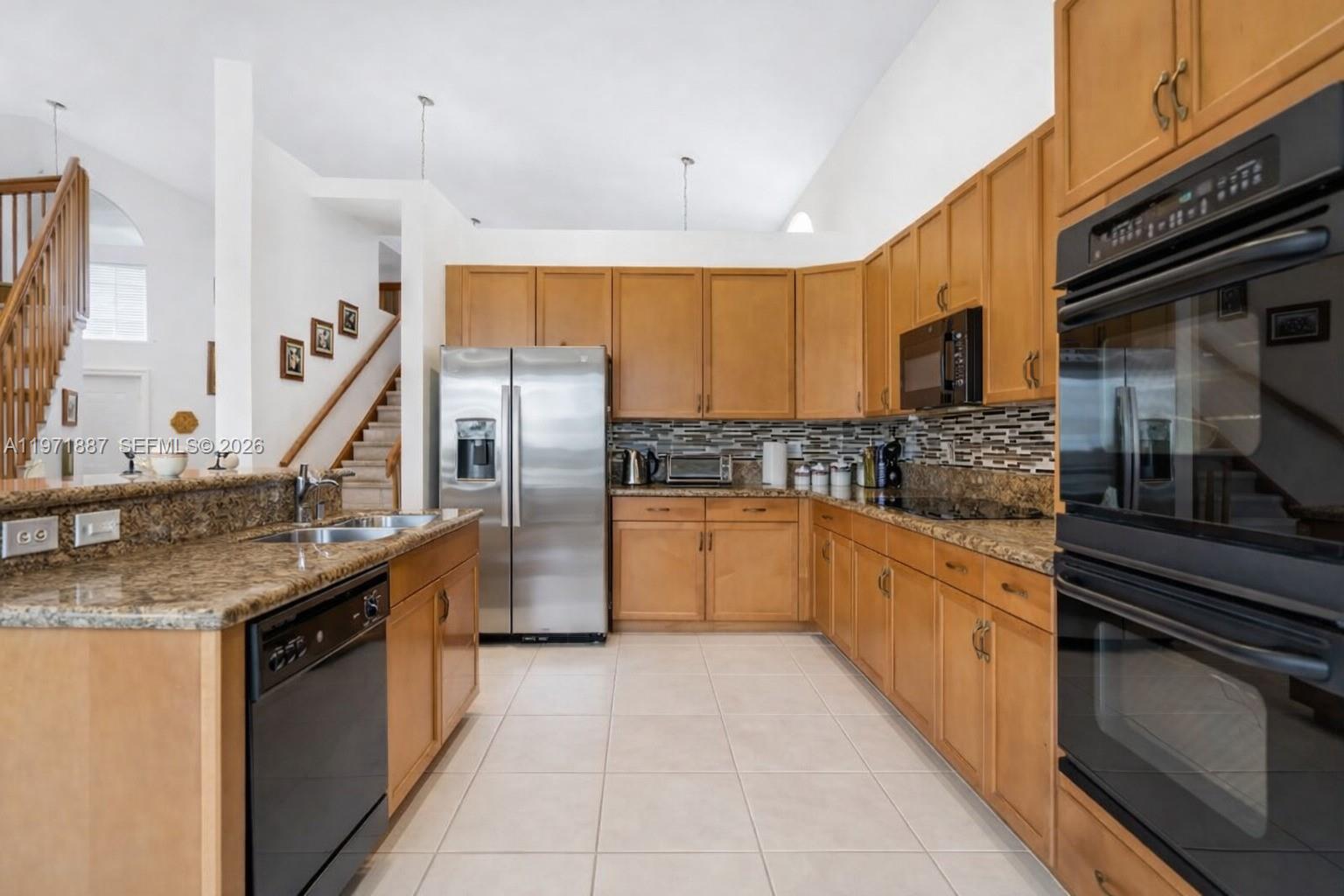 5321 Southwest 184th Way Miramar, FL 33029 - Photo 3 of 43 a kitchen with stainless steel appliances granite countertop a sink a stove and cabinets