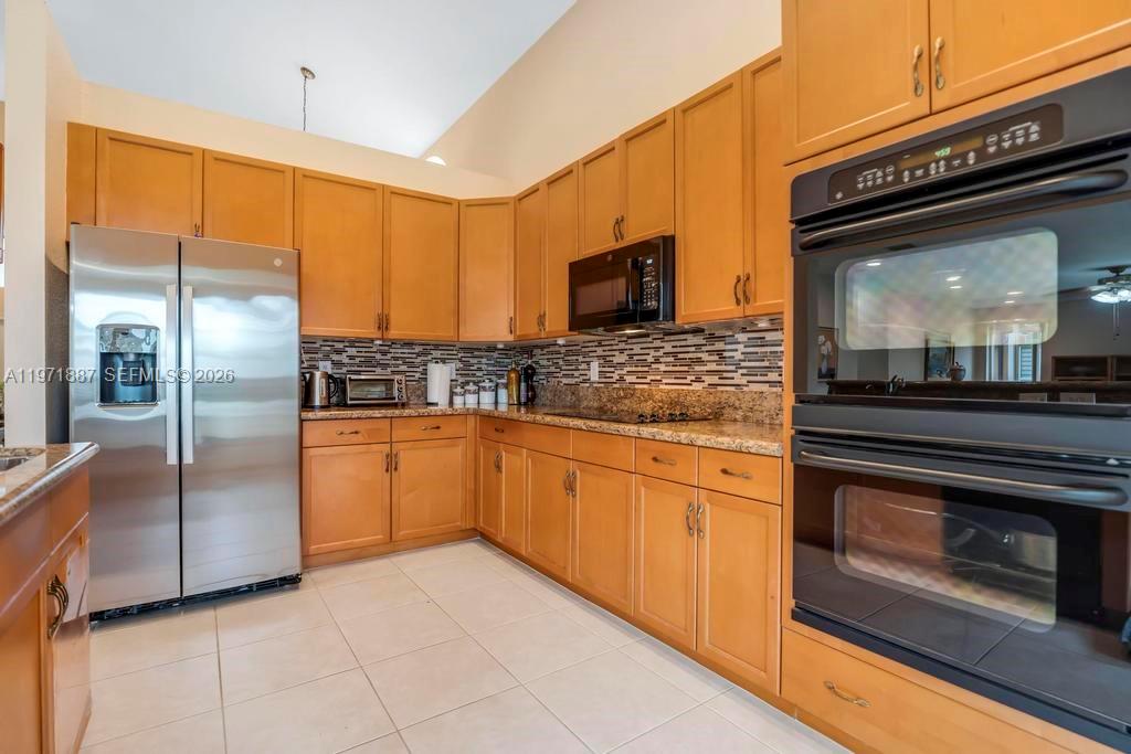 5321 Southwest 184th Way Miramar, FL 33029 - Photo 4 of 43 a kitchen with stainless steel appliances granite countertop a refrigerator a stove and a sink with wooden floor