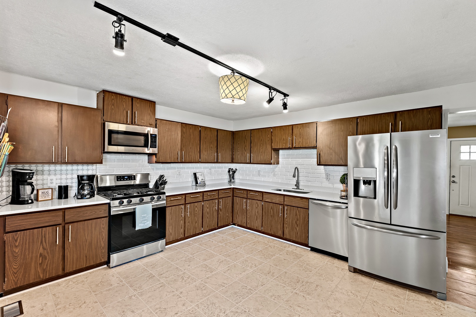 3248 River Road Kankakee, IL 60901 - Photo 6 of 32 a kitchen with stainless steel appliances granite countertop a refrigerator a stove top oven a sink dishwasher and white cabinets next to a window