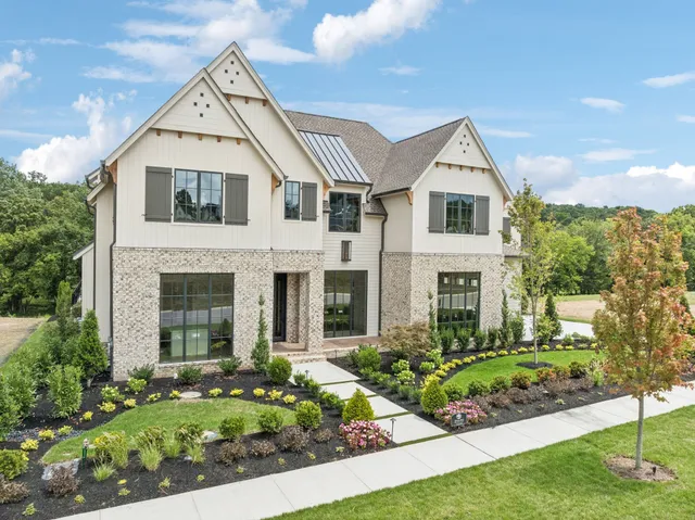 a front view of a house with a yard and a garden