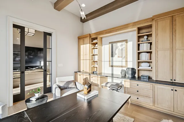 a kitchen with a stove a sink a center island and a wooden floor