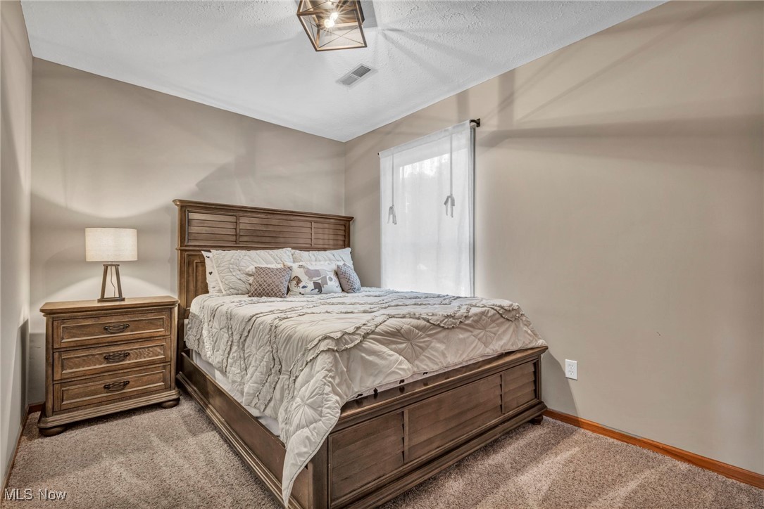 14902 Kneisel Road Vermilion, OH 44089 - Photo 25 of 49 Bedroom with light colored carpet and a textured ceiling