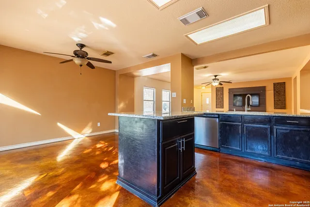 a kitchen with granite countertop a stove and a wooden cabinets