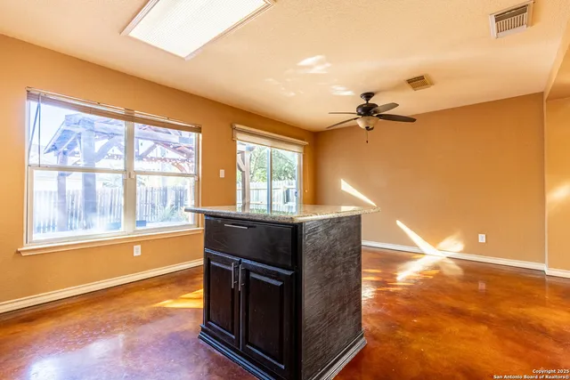 a living room with a dresser next to a window
