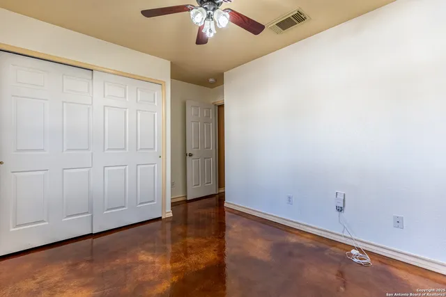an empty room with a chandelier fan