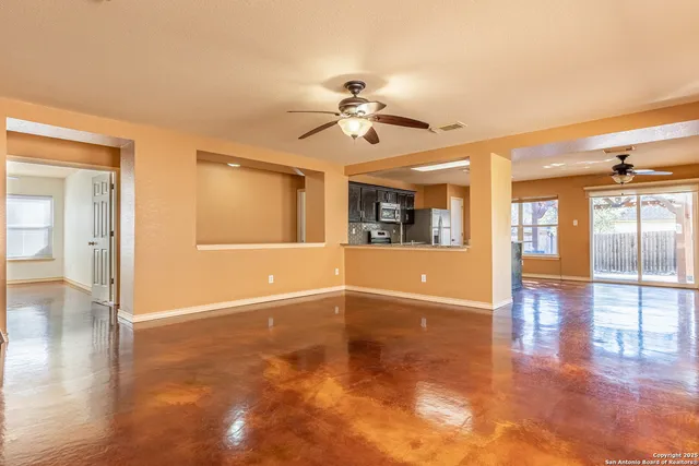 a view of an empty room with window and wooden floor