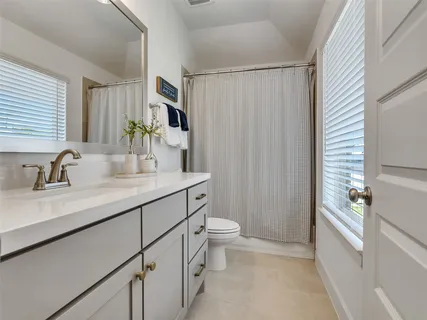 a bathroom with a double vanity sink toilet and shower