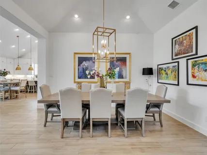 a view of a dining room with furniture a chandelier and wooden floor