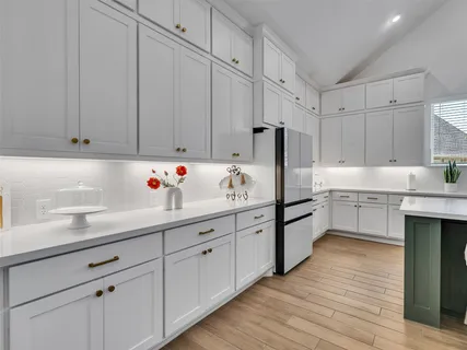 a kitchen with granite countertop white cabinets and white appliances
