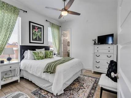 a bedroom with a bed a dresser and a chandelier