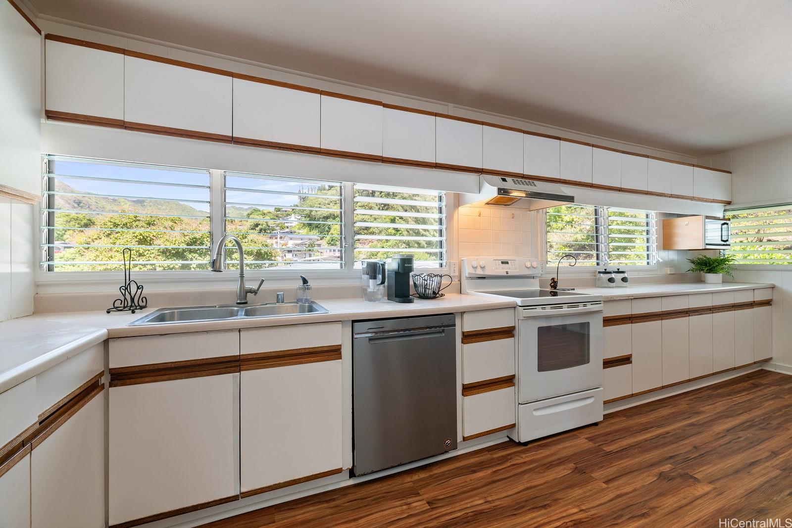 240 Puiwa Road Honolulu, HI 96817 - Photo 5 of 18 a kitchen with stainless steel appliances white cabinets and wooden floor