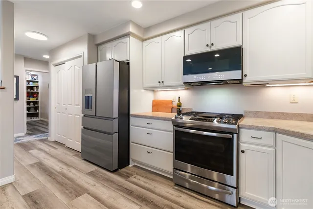 a kitchen with stainless steel appliances white cabinets and stove