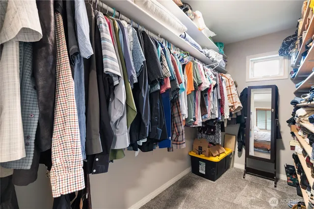 a view of walk in closet with clothes and shoes
