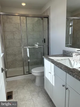 a bathroom with a granite countertop sink a toilet and shower