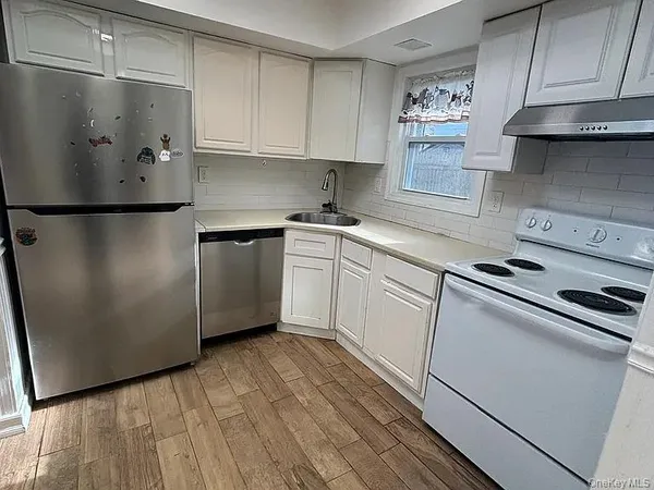 a kitchen with stainless steel appliances a refrigerator sink and cabinets