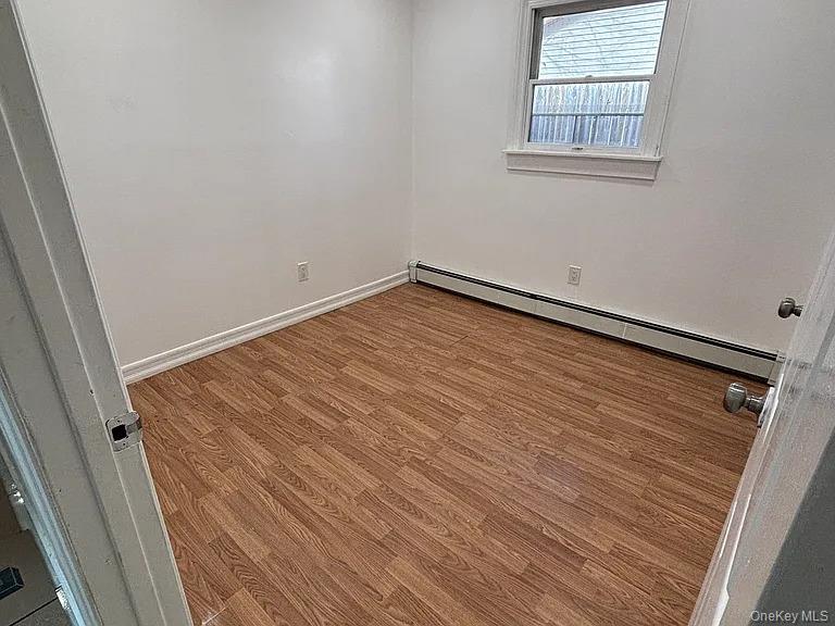61 Montgomery Avenue Mastic, NY 11950 - Photo 7 of 14 an empty room with wooden floor and windows