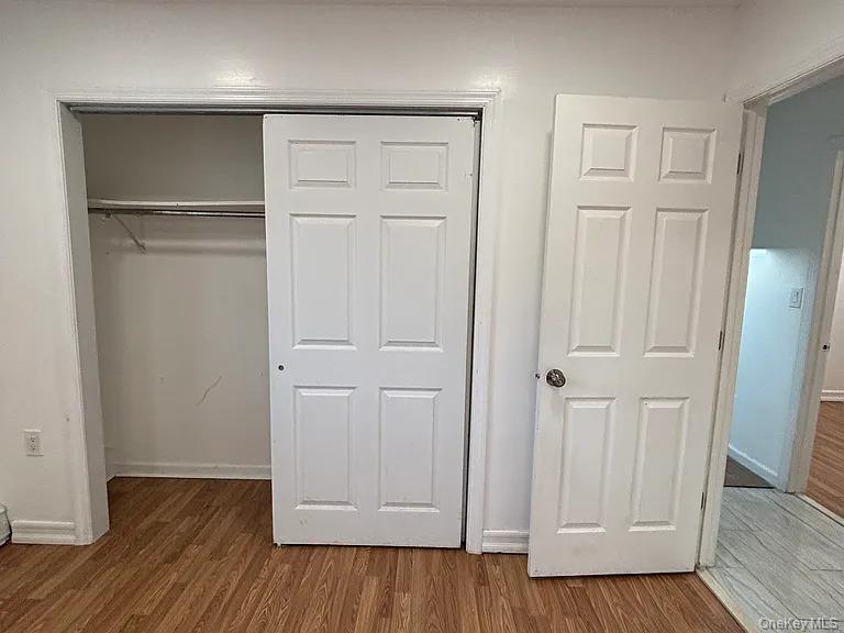 61 Montgomery Avenue Mastic, NY 11950 - Photo 9 of 14 an empty room with wooden floor & closet area