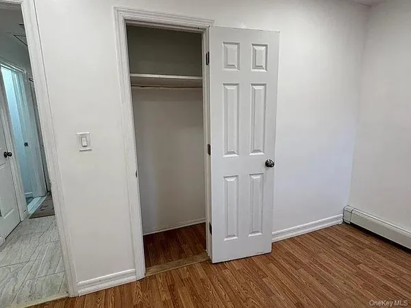an empty room with wooden floor and closet