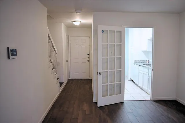 an empty room with wooden floor and a bathroom