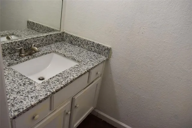 a bathroom with a granite countertop sink and vanity