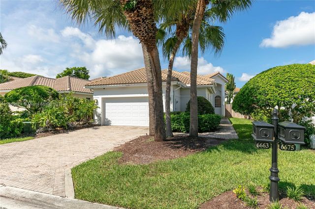 front view of a house with a yard and palm trees