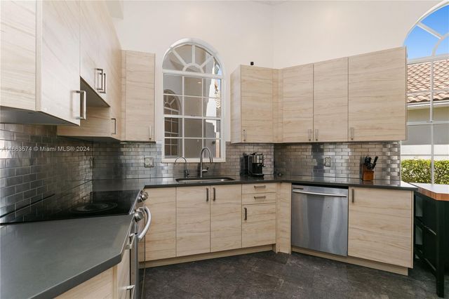 a kitchen with granite countertop a sink cabinets and window