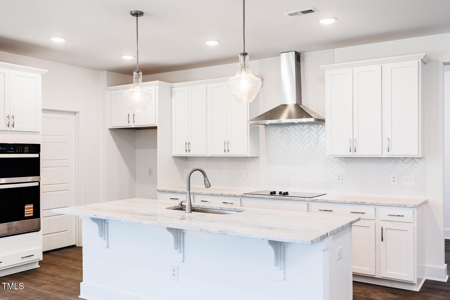 63 Tee Time Terrace Four Oaks, NC 27524 - Photo 3 of 36 a kitchen with stainless steel appliances a sink a stove a refrigerator and white cabinets with wooden floor