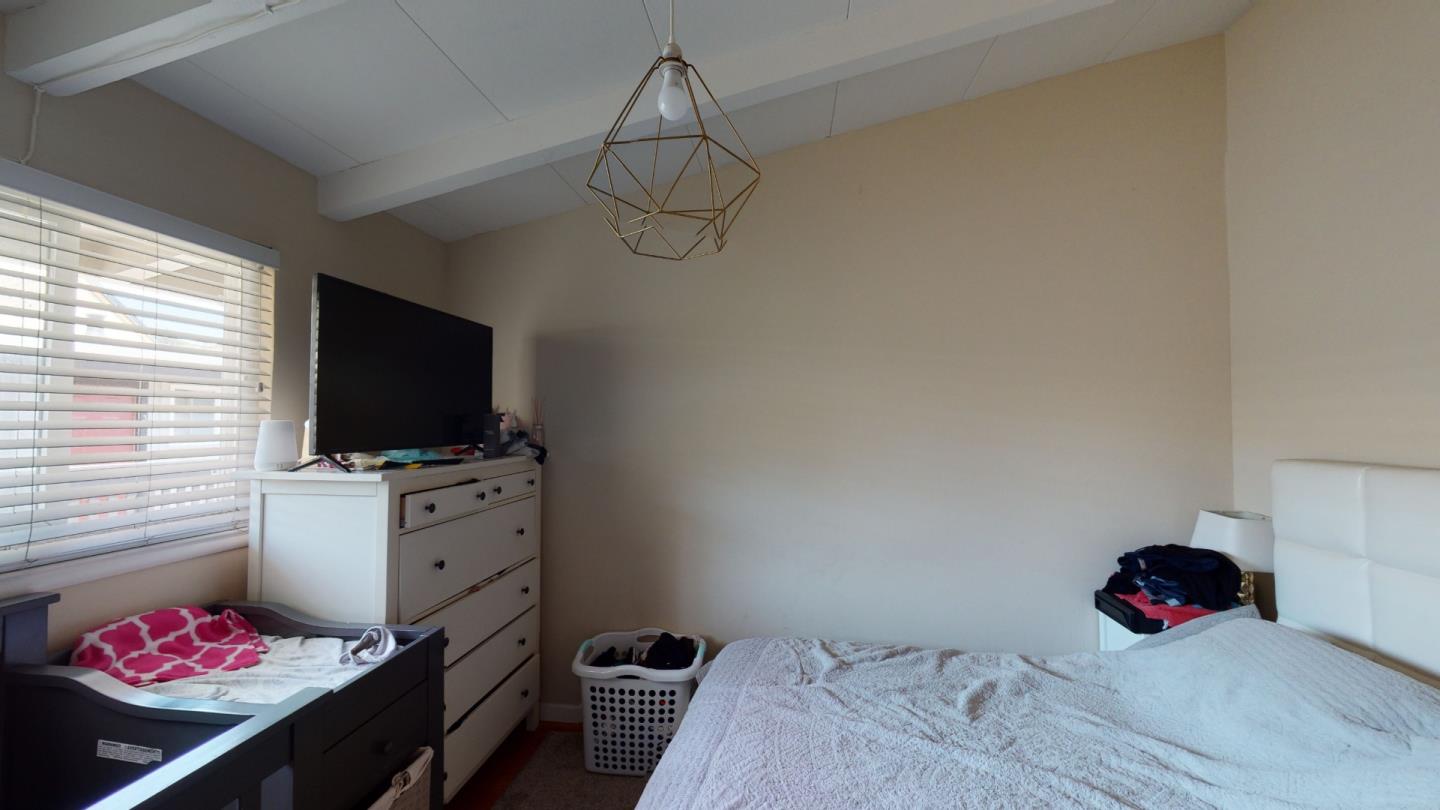 2408 Palmetto Avenue Pacifica, CA 94044 - Photo 29 of 51 a bedroom with a bed and flat screen tv