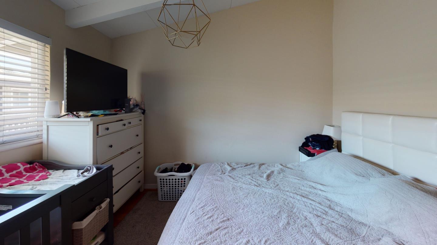 2408 Palmetto Avenue Pacifica, CA 94044 - Photo 31 of 51 a bedroom with a bed and flat screen tv