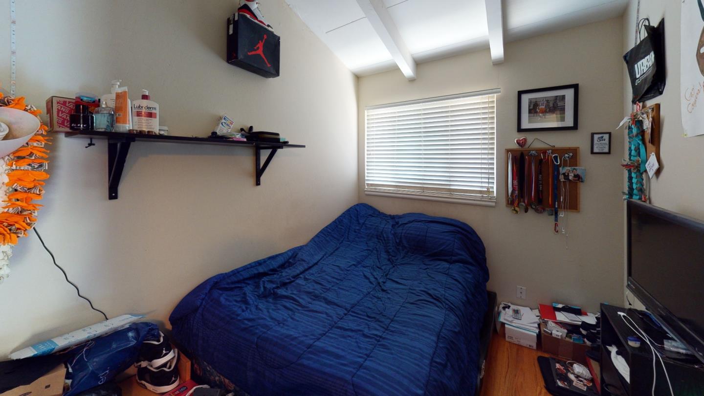 2408 Palmetto Avenue Pacifica, CA 94044 - Photo 32 of 51 a bedroom with a bed and a flat tv screen on the dresser