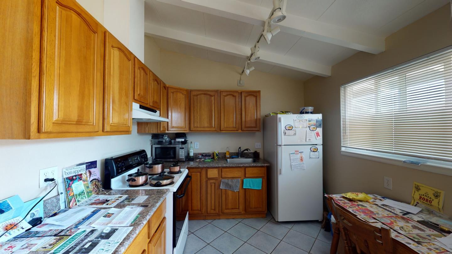 2408 Palmetto Avenue Pacifica, CA 94044 - Photo 37 of 51 a kitchen with a refrigerator a stove a sink dishwasher and wooden cabinets