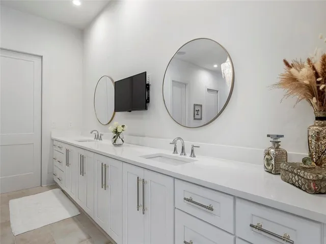 a bathroom with a toilet sink vanity granite and a mirror