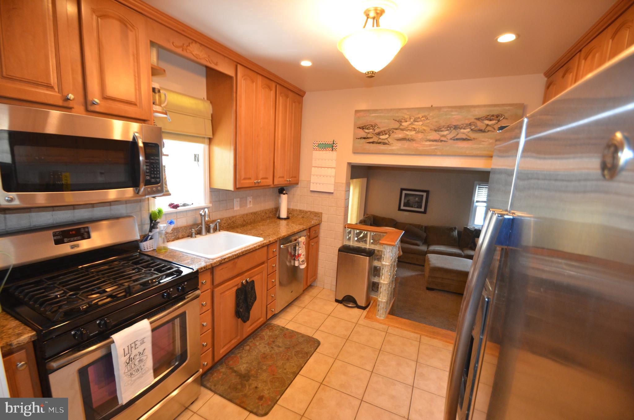 422 Madingley Road Linthicum Heights, MD 21090 - Photo 12 of 36 a kitchen with stainless steel appliances granite countertop a stove and a view of living room